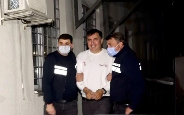 Saakashvili dikawal oleh petugas polisi saat ia tiba di sebuah penjara di Rustavi. Foto: Kementerian Dalam Negeri Georgia.