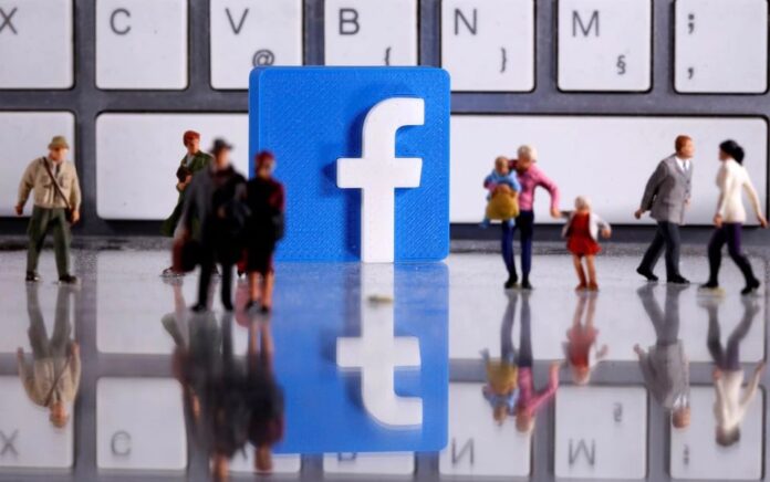 Logo Facebook cetak 3D ditempatkan di antara figur orang mainan kecil di depan keyboard dalam ilustrasi ini diambil 12 April 2020. Foto: Reuters.