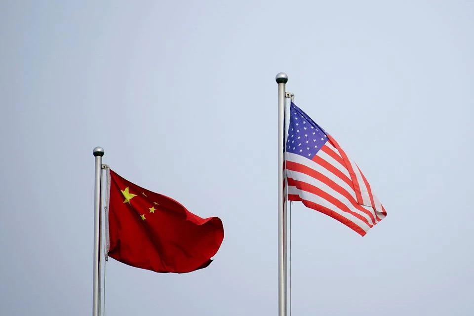 Bendera China dan AS berkibar di luar gedung perusahaan di Shanghai, China 14 April 2021. Foto: Reuters.