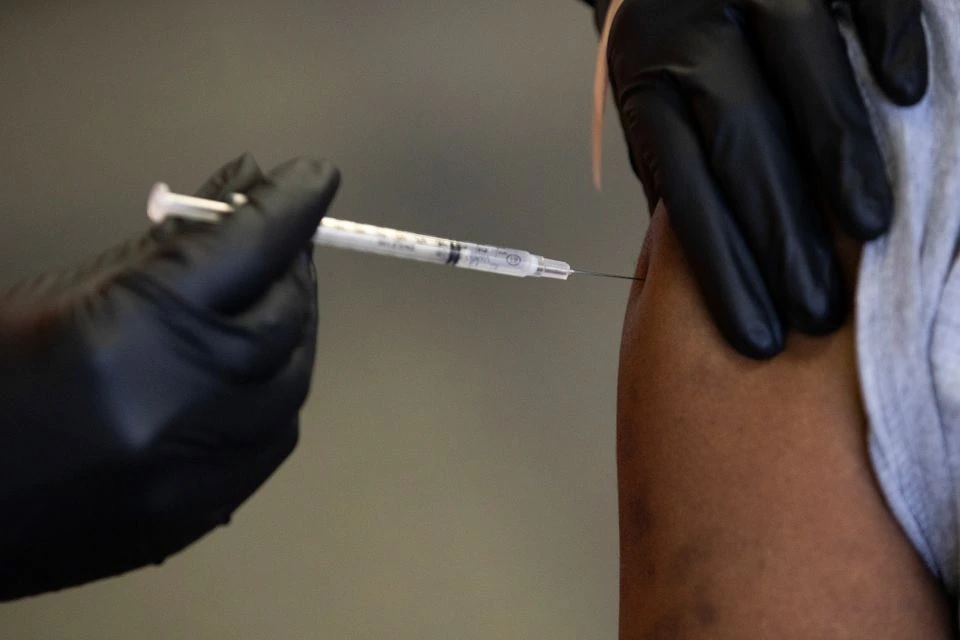 Seorang pasien menerima booster vaksin penyakit coronavirus (COVID-19) mereka selama klinik vaksinasi Pfizer-BioNTech di Southfield, Michigan, AS, 29 September 2021. Foto: Reuters.