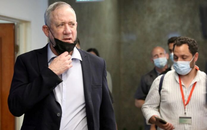 Menteri Pertahanan Israel Benny Gantz berjalan melewati media selama pertemuan kabinet mingguan di Yerusalem, 1 Agustus 2021. Foto: Reuters.