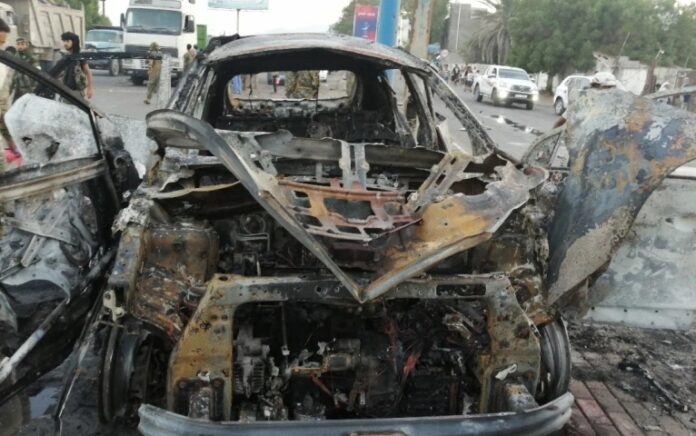 Seorang petugas keamanan memeriksa puing-puing mobil di lokasi ledakan yang menewaskan seorang jurnalis di Aden, Yaman. Foto: Reuters.