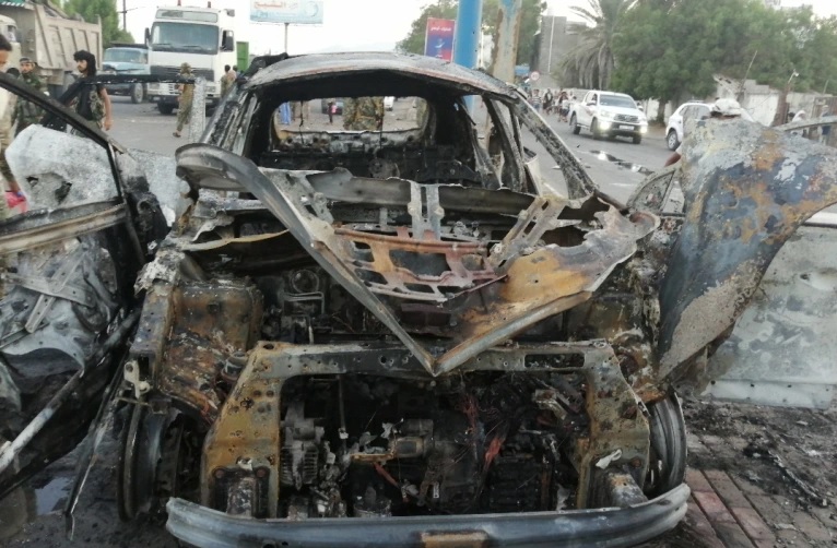 Seorang petugas keamanan memeriksa puing-puing mobil di lokasi ledakan yang menewaskan seorang jurnalis di Aden, Yaman. Foto: Reuters.