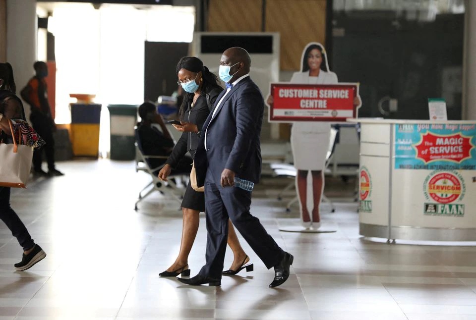 Orang-orang yang memakai masker berjalan di dalam Bandara Internasional Nnamdi Azikiwe, pada hari pembukaan kembali untuk operasi penerbangan domestik, setelah wabah penyakit virus corona (COVID-19), di Abuja, Nigeria, 8 Juli 2020. Foto: Reuters.