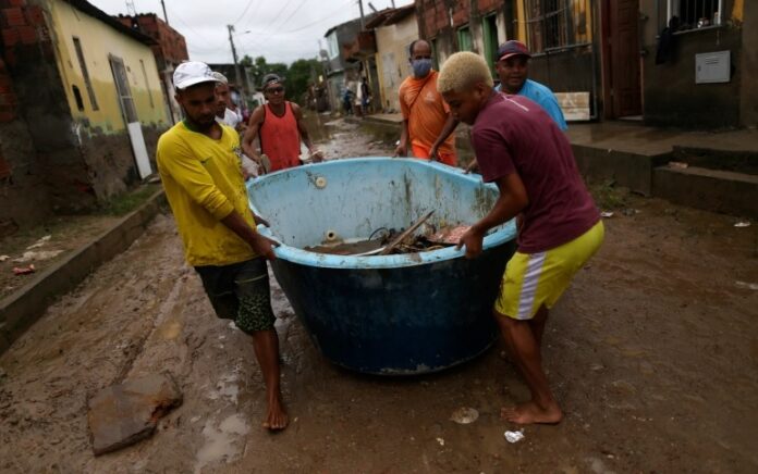 Warga mencoba menyelamatkan diri dari banjir mematikan Brasil dan Brasil gelontorkan puluhan juta dollar. Foto: AP Photo.