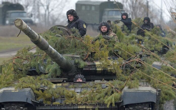 Anggota angkatan bersenjata Ukraina mengendarai tank menuju jembatan ponton sebelum menyeberangi Sungai Aidar selama latihan militer di dekat Novoaidar di wilayah Luhansk, Ukraina, 14 Desember 2021. Foto: Reuters.