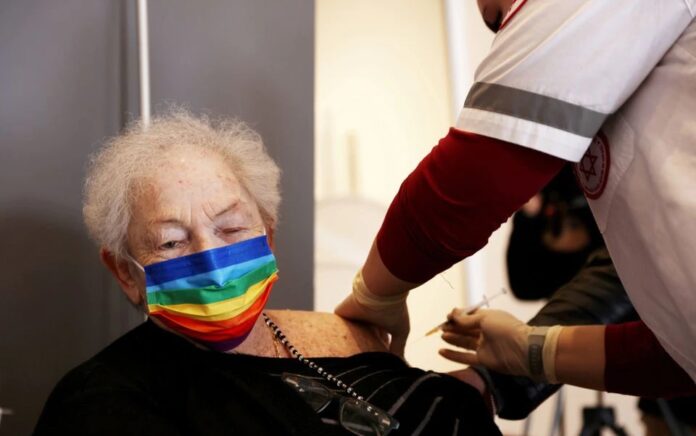 Seorang wanita tua menerima suntikan booster di Netanya, Israel 19 Januari 2021. Foto: Reuters.