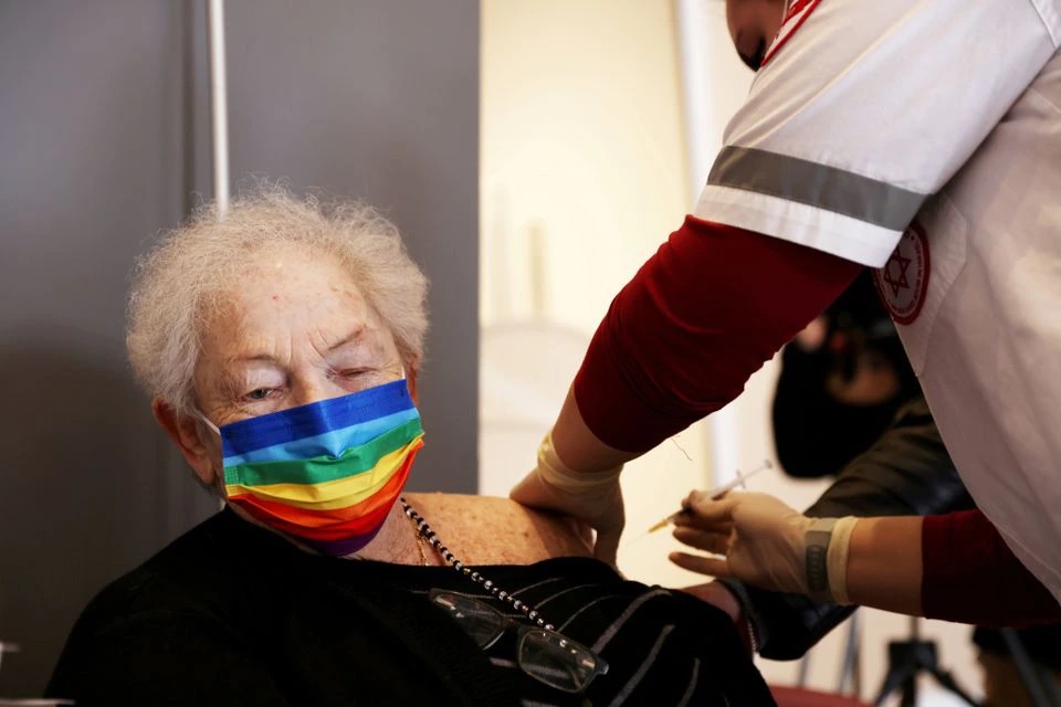 Seorang wanita tua menerima suntikan booster di Netanya, Israel 19 Januari 2021. Foto: Reuters.