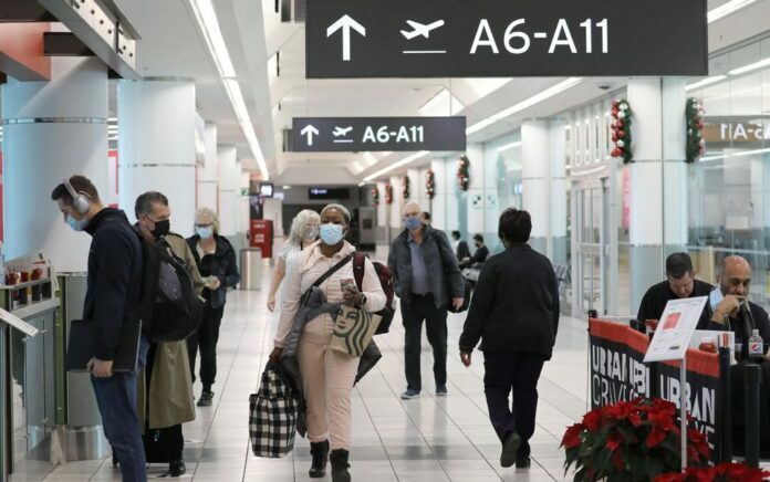 Penumpang tujuan Amerika Serikat berjalan di Terminal 3 Bandara Toronto Pearson, beberapa hari sebelum protokol pengujian penyakit virus corona baru (COVID-19) untuk memasuki AS mulai berlaku, di Toronto, Ontario, Kanada 3 Desember 2021. Foto: Reuters.