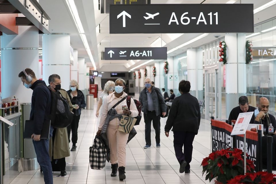 Penumpang tujuan Amerika Serikat berjalan di Terminal 3 Bandara Toronto Pearson, beberapa hari sebelum protokol pengujian penyakit virus corona baru (COVID-19) untuk memasuki AS mulai berlaku, di Toronto, Ontario, Kanada 3 Desember 2021. Foto: Reuters.