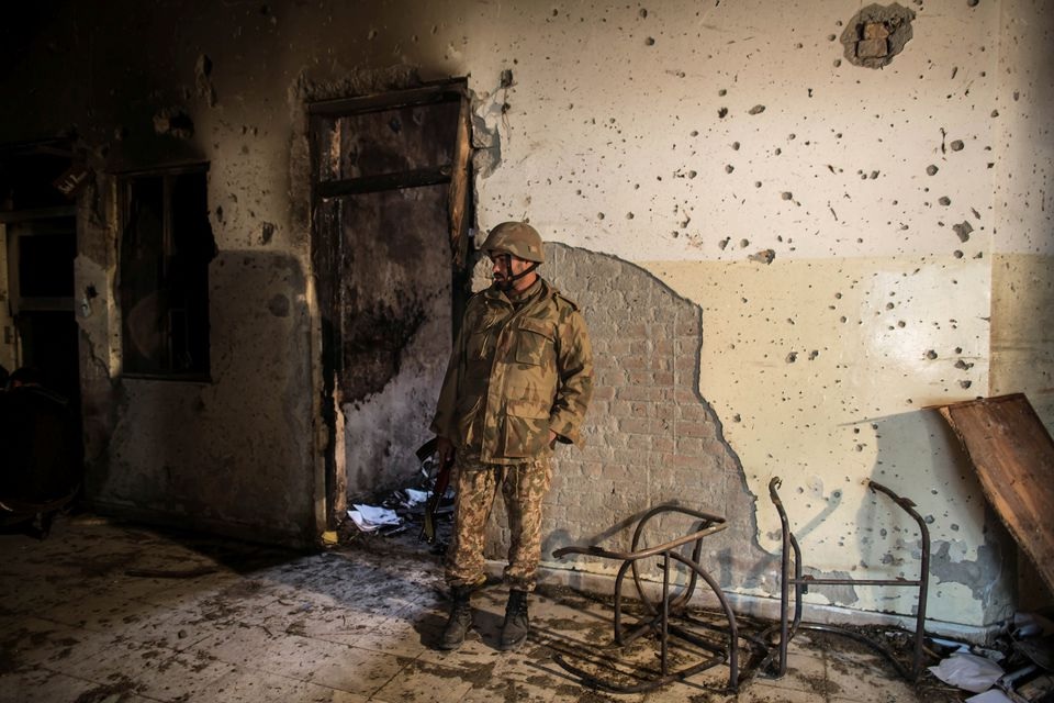 Seorang tentara memeriksa Sekolah Umum Angkatan Darat, yang diserang oleh kelompok bersenjata Taliban, di Peshawar, 17 Desember 2014. Foto: Reuters.