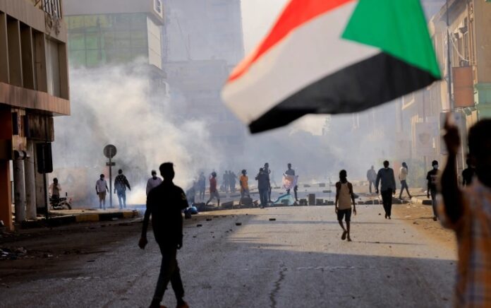 Orang-orang berbaris ke istana presiden, memprotes pemerintahan militer menyusul kudeta bulan lalu di Khartoum, Sudan pada 19 Desember 2021. Foto: Reuters.