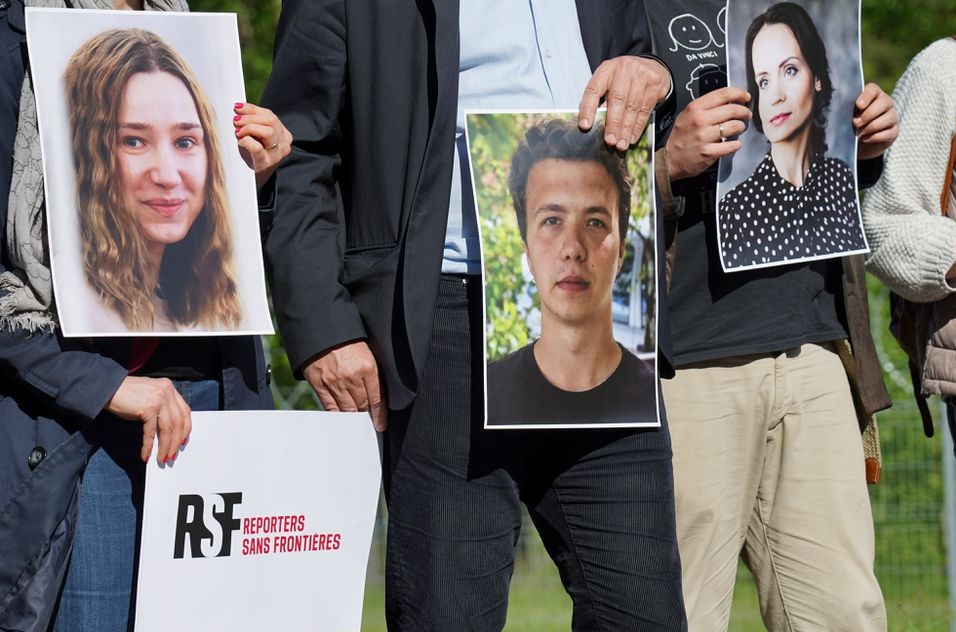 Kelompok advokasi pers Aktivis Reporters Sans Frontiers memegang foto wartawan yang ditahan di Belarus di titik penyeberangan perbatasan Salcininkai, Lithuania pada 27 Mei 2021. Foto: Reuters.