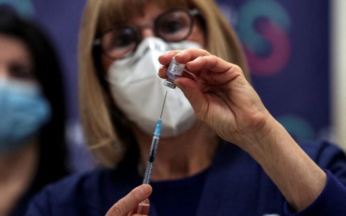 Seorang perawat menyiapkan vaksin penyakit coronavirus (COVID-19) dosis keempat sebagai bagian dari uji coba di Israel, di Sheba Medical Center di Ramat Gan, Israel 27 Desember 2021. Foto: Reuters.