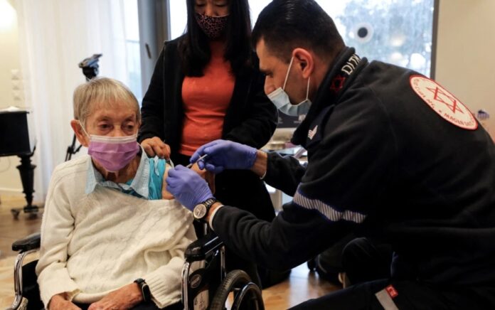 Lili Zohari, 90 tahun, menerima dosis keempat vaksin COVID-19 di panti jompo di Netanya, Israel, 5 Januari 2022. Foto: Reuters.
