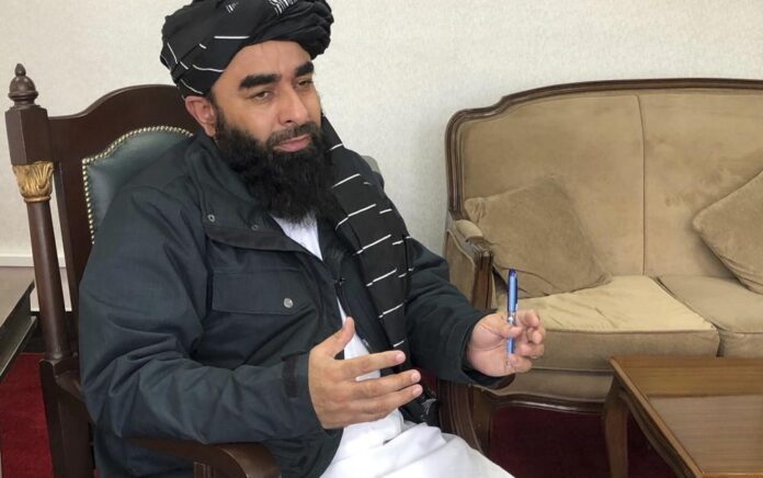 Juru bicara pemerintah Taliban Zabihullah Mujahid berbicara selama wawancara dengan Associated Press di Kabul, Afghanistan, Sabtu, 15 Januari 2022. Foto: AP News.