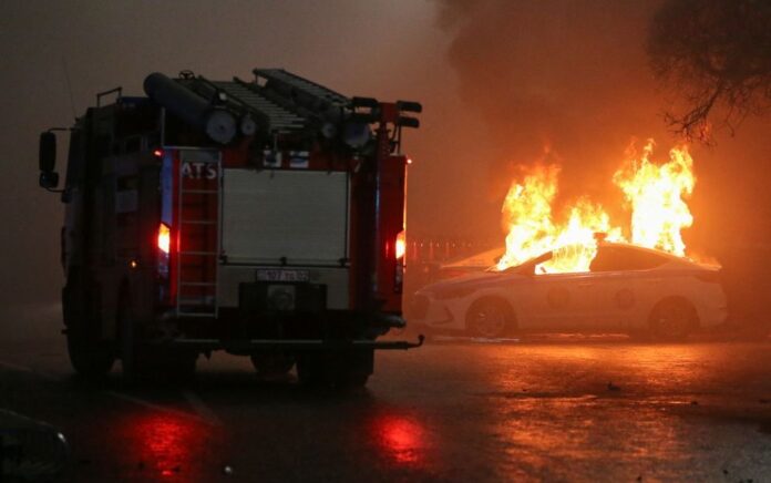 Sebuah pemandangan menunjukkan mobil polisi yang terbakar selama protes terhadap kenaikan harga minyak di Almaty, Kazakhstan 5 Januari 2022. Foto: Reuters.