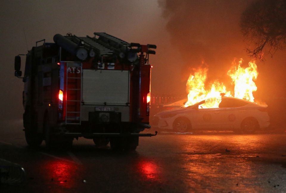 Sebuah pemandangan menunjukkan mobil polisi yang terbakar selama protes terhadap kenaikan harga minyak di Almaty, Kazakhstan 5 Januari 2022. Foto: Reuters.