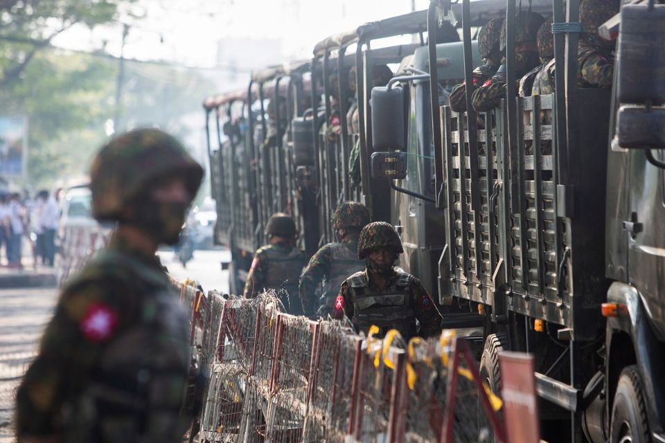 Tentara berdiri di samping kendaraan militer ketika orang-orang berkumpul untuk memprotes kudeta militer, di Yangon, Myanmar, 15 Februari 2021. Foto: Reuters.