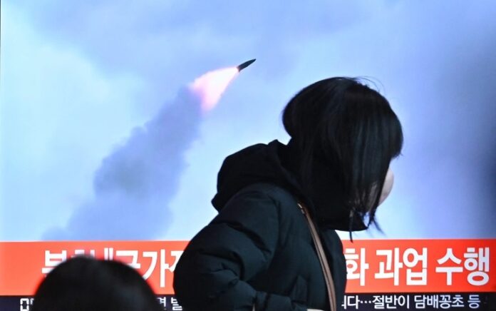 Seorang warga melihat peluncuran rudal balistik melalui televisi. Foto: AFP.