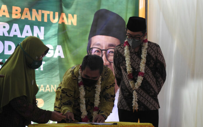 Penandatanganan Ketua Komisi VI DPR RI, Faisol Riza dan BUMN saat menyalurkan bantuan kepada PCNU, Muslimat NU, Fatayat NU, PC GP Ansor Kraksaan, Probolinggo, Jawa Timur. (Foto: Istimewa)