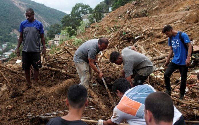 Warga menemukan mayat istrinya di lokasi tanah longsor di Morro da Oficina setelah hujan lebat di Petropolis. Foto: Reuters.