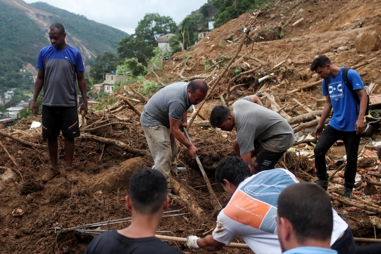 Warga menemukan mayat istrinya di lokasi tanah longsor di Morro da Oficina setelah hujan lebat di Petropolis. Foto: Reuters.
