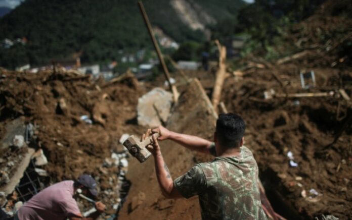 Seorang petugas sedang berusaha mencari korban di tengah puing-puing. Foto: Reuters.