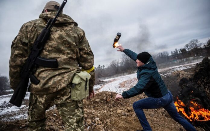 Seorang warga sipil berlatih melempar bom molotov untuk mempertahankan kota, saat invasi Rusia ke Ukraina masih berlanjut, di Zhytomyr, Ukraina 1 Maret 2022. Foto: Reuters/Viacheslav Ratynskyi.