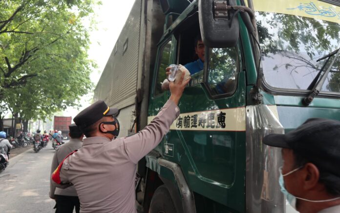 Jalur Pantura Gresik Macet Total, Kapolsek Manyar Bagikan Nasi Bungkus dan Air Mineral