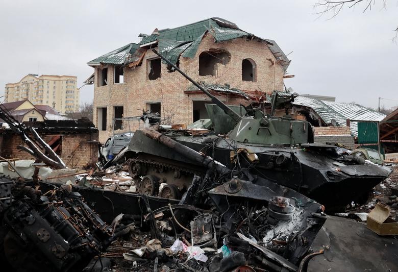 Sebuah kendaraan lapis baja yang hancur, dengan huruf "V" dicat di menaranya, terlihat di sebuah jalan di kota Bucha di wilayah Kiev, Ukraina, 1 Maret. Foto: Reuters/Serhii Nuzhnenko.