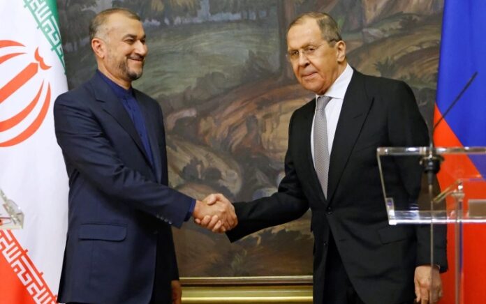 Menteri Luar Negeri Rusia Sergei Lavrov berjabat tangan dengan Menteri Luar Negeri Iran Hossein Amir-Abdollahian selama konferensi pers bersama di Moskow, Rusia 15 Maret 2022. Foto: Pool/Reuters.