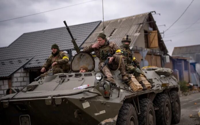 Tentara Ukraina mengendarai kendaraan militer lapis baja di pinggiran Kyiv, Ukraina, pada 5 Maret 2022. Foto: AP/Emilio Morenatti.