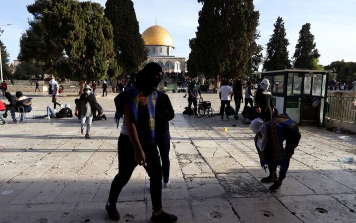 Para pengunjuk rasa Palestina berjalan di sekitar selama bentrokan dengan pasukan keamanan Israel di kompleks Masjid Al-Aqsa, di Kota Tua Yerusalem 22 April 2022. Foto: Reuters/Ammar Awad.