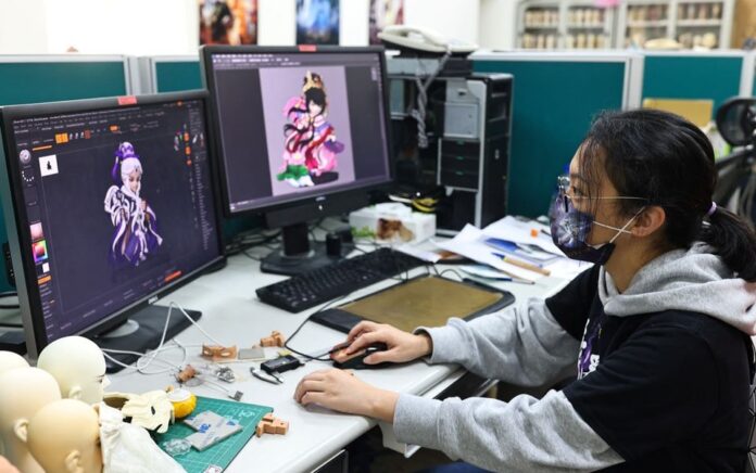 Seika Huang, direktur merek Pili International Multimedia, melihat desain karakter yang diubah menjadi file NFT di kantor pusat mereka di Yunlin, Taiwan, 18 Februari 2022. Foto: Reuters/Ann Wang.