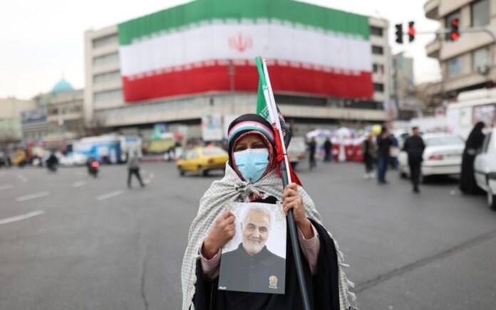 Seorang wanita Iran memegang foto mendiang Mayor Jenderal Iran Qassem Soleimani, saat perayaan ulang tahun ke-43 Revolusi Islam di Teheran, Iran, 11 Februari 2022. Foto: Majid Asgaripour/WANA via Reuters.