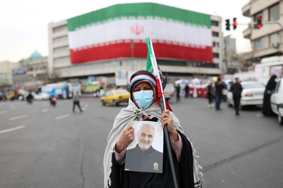 Seorang wanita Iran memegang foto mendiang Mayor Jenderal Iran Qassem Soleimani, saat perayaan ulang tahun ke-43 Revolusi Islam di Teheran, Iran, 11 Februari 2022. Foto: Majid Asgaripour/WANA via Reuters.