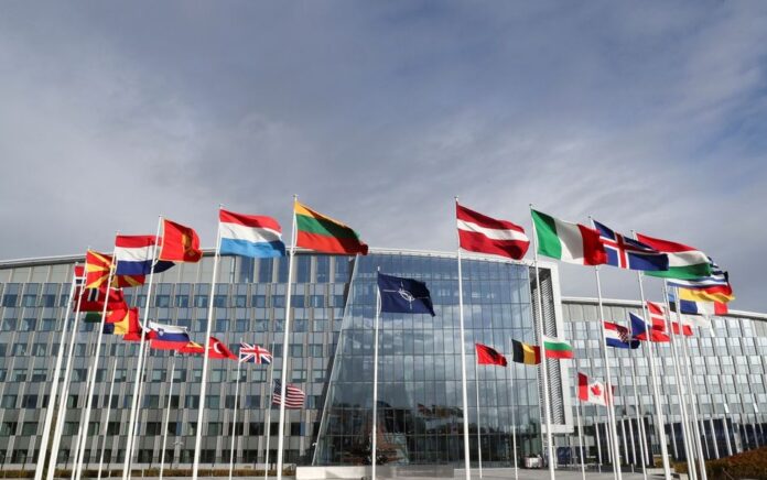 Bendera berkibar di luar markas Aliansi menjelang pertemuan Menteri Pertahanan NATO, di Brussels, Belgia, 21 Oktober 2021. Foto: Reuters/Pascal Rossignol.