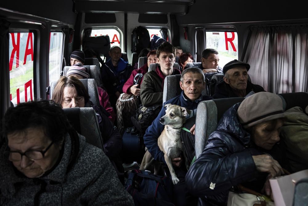 Orang-orang duduk di dalam bus saat evakuasi dari Lyman, wilayah Donetsk, Ukraina timur, Sabtu, 30 April 2022. Foto: AP Photo/Evgeniy Maloletka.