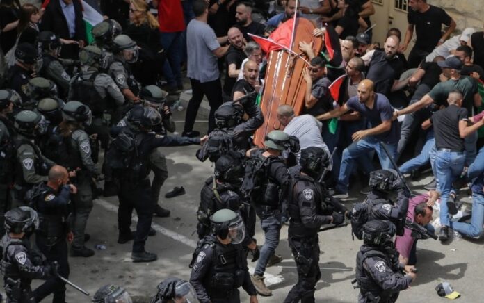 Pembawa peti keranda Shireen Abu Akhleh diserbu Polisi saat prosesi pemakamannya pada Jumat, 13 Mei 2022. Foto: Maya Levin/AP Photo.