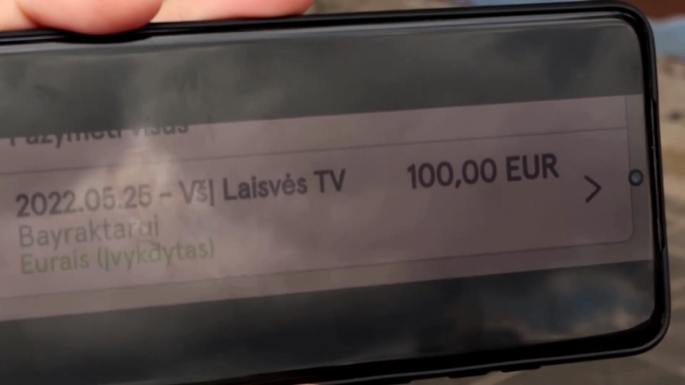 Seorang warga Lithuania menunjukkan dirinya telah menransfer uang 100 Eureo ke Laisves TV. Foto: Reuters.