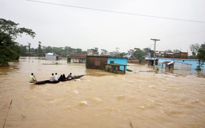 Orang-orang memindahkan perahu di daerah banjir saat banjir meluas di bagian timur laut negara itu, di Sylhet, Bangladesh, 19 Juni 2022. Foto: Reuters/Stringer.