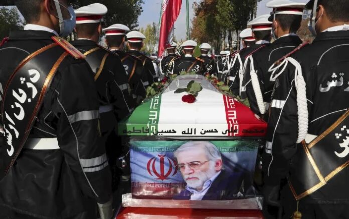 Personel militer Iran berdiri di dekat peti mati berbendera yang membahwa jenazah Mohsen Fakhrizadeh, seorang ilmuwan yang terbunuh, saat upacara pemakaman di Teheran, Iran, Senin, 30 November. 2020. Foto: Kementerian Pertahanan Iran via AP.