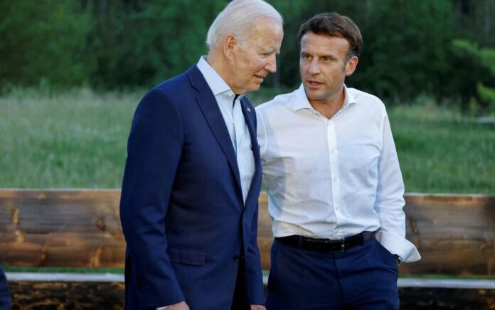 Presiden AS Joe Biden dan Presiden Prancis Emmanuel Macron berbicara setelah berpose untuk foto kelompok informal di bangku setelah makan malam kerja selama KTT G7 yang diadakan di Kastil Elmau, di Kruen dekat Garmisch-Partenkirchen, Jerman 26 Juni 2022. Foto: Ludovic Marin /Kolam renang melalui Reuters.