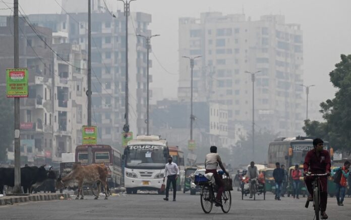 Para komuter berjalan di tengah kondisi kabut asap di New Delhi. Foto: Prakash Singh/AFP.