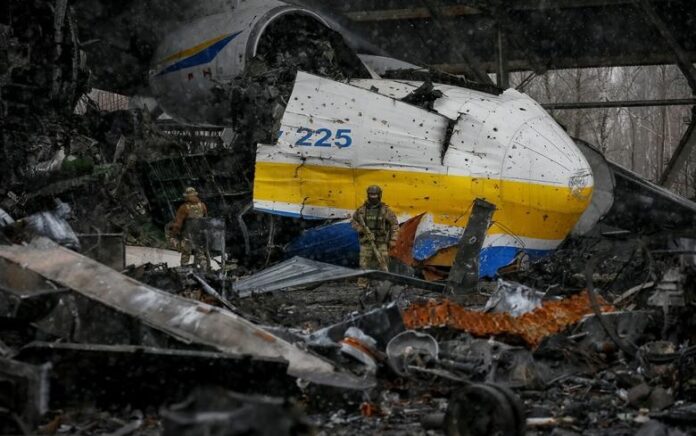 Seorang anggota layanan Ukraina berjalan di depan pesawat kargo Antonov An-225 Mriya, pesawat terbesar di dunia, dihancurkan oleh pasukan Rusia, di sebuah lapangan terbang di pemukiman Hostomel, di wilayah Kyiv, Ukraina 3 April. Foto: Reuters/Gleb Garanich.