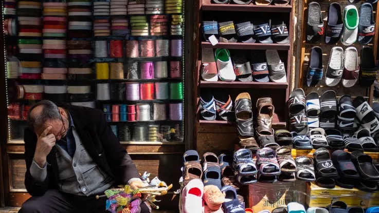 Seorang pria menjual sandal di Eminonu pada 5 Mei 2022, di Istanbul, Turki. Foto: Burak Kara/Getty Images.
