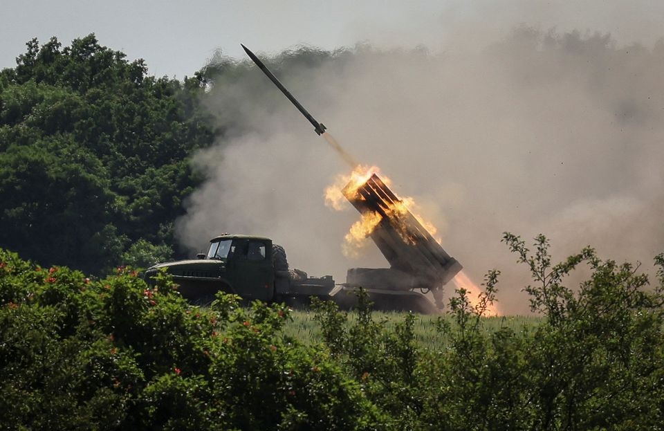 Anggota layanan Ukraina menembakkan sistem peluncuran roket ganda BM-21 Grad, dekat kota Lysychansk, wilayah Luhansk, di tengah serangan Rusia ke Ukraina 12 Juni 2022. Foto: Reuters/Gleb Garanich.