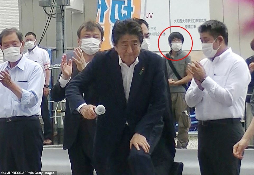 Pria yang dilingkari merah, diyakini sebagai tersangka penembakan mantan Perdana Menteri Jepang Shinzo Abe ditahan oleh petugas polisi di Stasiun Yamato Saidaiji di Nara, Prefektur Nara pada 8 Juli 2022. Foto: Jiji Press/AFP via Getty Images.