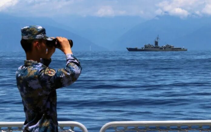 Seorang anggota tentara militer China meneropong kapal militer fregat Taiwan Lan Yang yang ada di dekatnya. China mengadakan latihan di perairan sekitar Taiwan sebagai tanggapan atas kunjungan Ketua DPR AS Nancy Pelosi baru-baru ini. Foto: Lin Jian/Xinhua/AP.